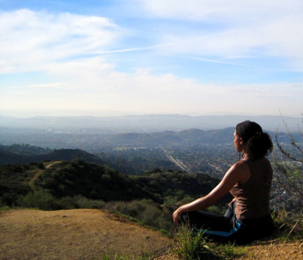 Woman overlooking calm mountains and skyline in meditation