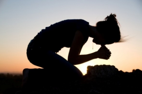 Woman on her knees praying