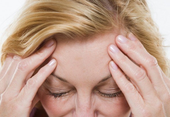 woman suffering from pain holding head